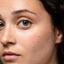 Mujer de piel normal con pecas y ojos marrones.